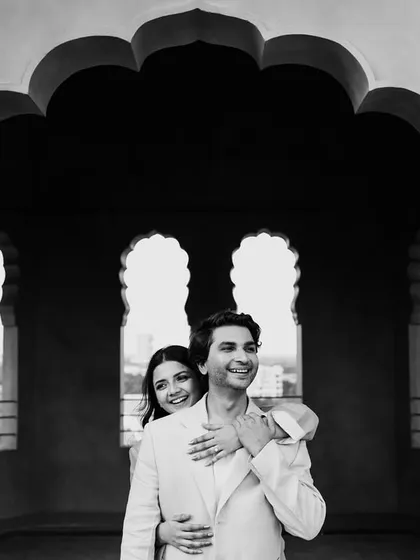 Framed by a traditional Rajasthani archway, this couple shares a warm embrace. The silhouette effect in this black and white image adds a touch of drama and intimacy to their pre-wedding portrait.