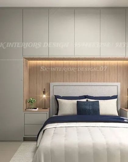 A calm and clutter-free bedroom with floor-to-ceiling wardrobes built around the bed. The light grey and wood tones, along with the mirrored wardrobe panel, create a spacious and serene environment.