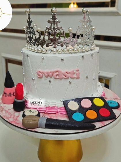 A cake fit for a queen. This design is perfect for a makeup lover, complete with edible lipstick, an eyeshadow palette, and a beautiful crown topper.