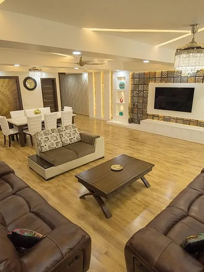 We believe in creating open, inviting living spaces where families can connect. This expansive living and dining area showcases a blend of luxurious leather sofas, elegant lighting, and warm wooden flooring, all designed to create a grand yet comfortable atmosphere for both daily life and entertaining guests.