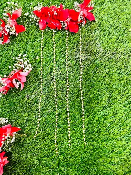 Detail of the floral strings from the red dohale jevan set, showing how delicate pearl-like buds are used to create length and movement.