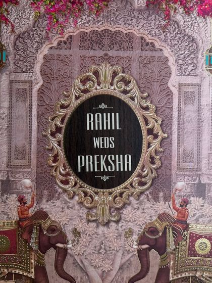 The cover of this invitation features a stunning composition of royal elephants, intricate jali patterns, and a bold, ornate frame for the couple's names.