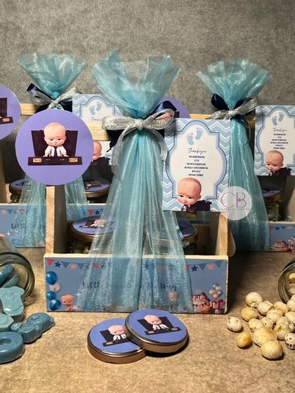 These "Boss Baby" themed return gift favours are perfect for a baby shower or first birthday. The pinewood baskets are filled with themed chocolates and flavoured foxnuts, all wrapped in blue tulle.