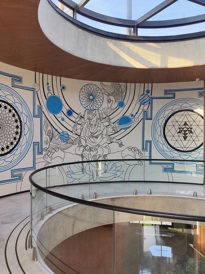 Another shot of the spiritual-themed mural in the circular atrium, showing how the line art interacts with the modern glass railing and the light from the dome above.