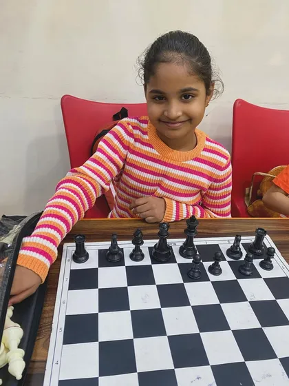 A young student proudly sets up her pieces for a game. I aim to instill a lifelong love for chess by making our classes engaging and rewarding.