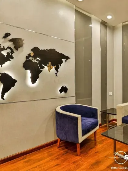 A modern office waiting area featuring a backlit world map as a statement piece. The combination of plush blue armchairs and sleek side tables creates a globally-inspired, professional ambiance.