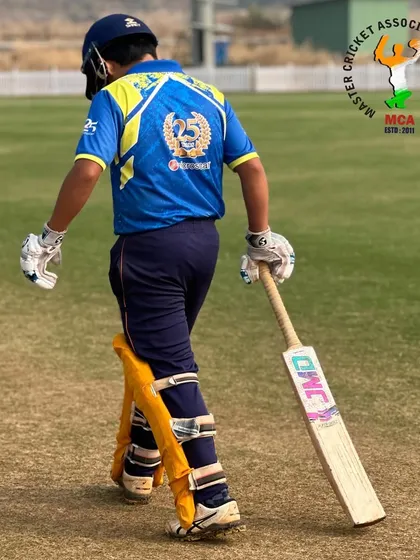 A young batsman from our academy, fully padded up and walking with purpose towards the crease during a T-20 series match.