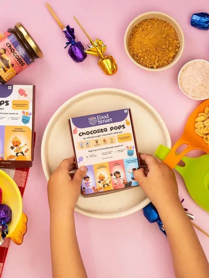 A playful flat lay for Feedsmart's healthy kids' snacks, showing a child's hands holding the product. This creates an engaging and family-friendly brand image.