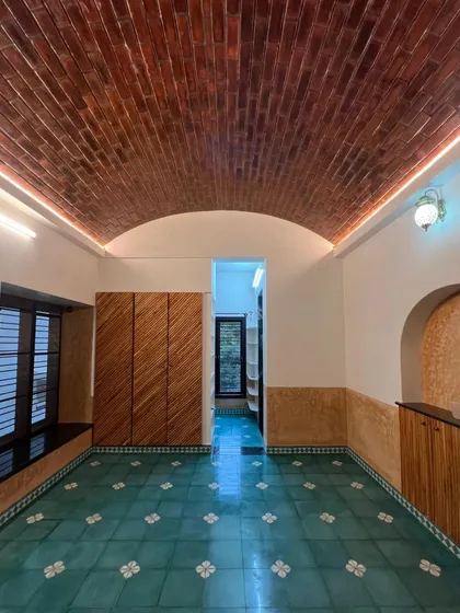A bedroom featuring a segmental brick vault ceiling, athangudi tile flooring, and lime-plastered walls. This image shows how we combine multiple traditional materials to create a rich, layered, and harmonious interior.