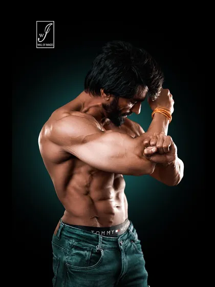 An artistic pose focusing on the abs and obliques. The way the athlete holds his arm creates tension that makes the core muscles pop, demonstrating incredible control and definition.