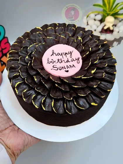 A close-up of our bestseller chocolate petal cake, this time with a pink "Happy Birthday" plaque.