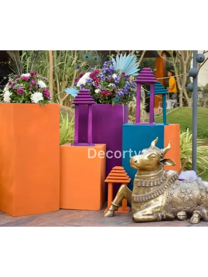 A decorative corner with a brass Nandi statue and colorful props, enhancing the traditional theme.