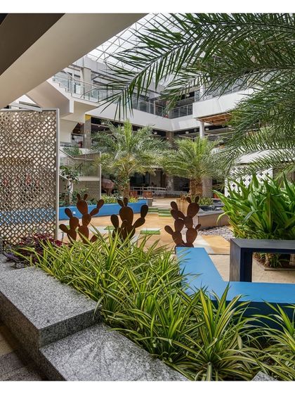 A courtyard at SAP Labs featuring a mix of desert and tropical planting, with sculptural cacti and laser-cut screens. This eclectic design provides a variety of themed zones for employees to work, meet, or relax.