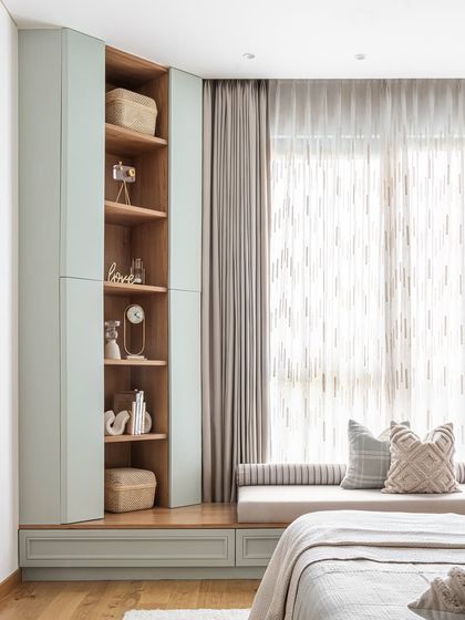 On the other side of the grandparents' room, we created this charming window seat. It doubles as a cozy reading nook with both open and closed storage, offering a serene spot to relax while basking in natural light. It's neat, clean, and just pretty.