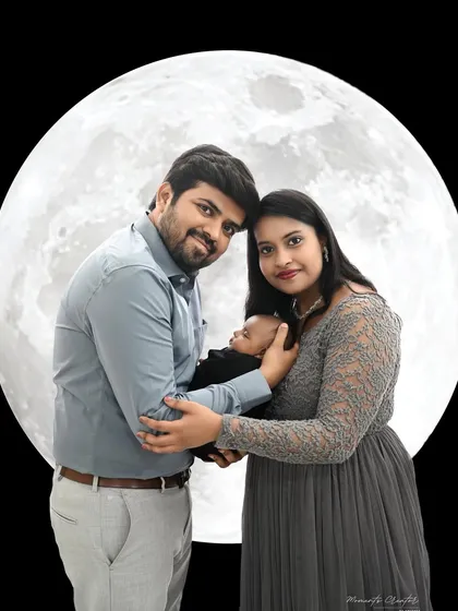A sweet family portrait in front of a glowing moon. This creative shot is a wonderful way to capture the magic of welcoming a new baby into the family.