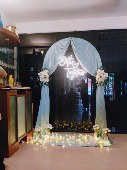 A "Better Together" neon sign as the centerpiece of an anniversary or engagement party entrance arch.