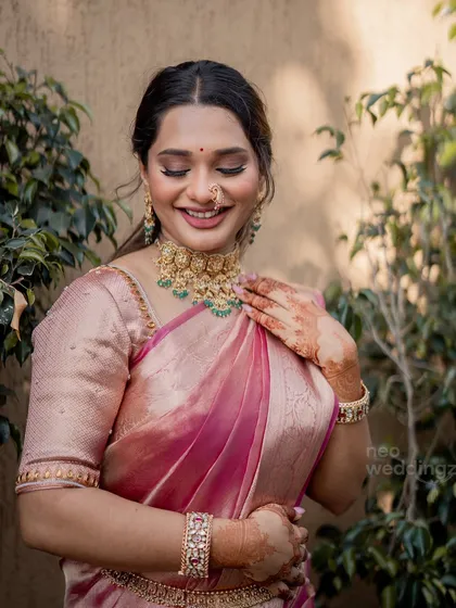 A lovely, soft-focus shot of Isha. Her makeup enhances her features beautifully, creating a look that is both traditional and fresh.