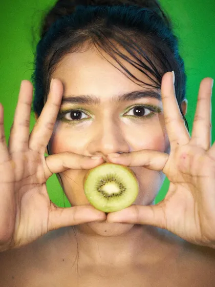 Using a kiwi and matching green makeup to create a cohesive and striking beauty shot. This demonstrates my ability to work with creative, color-coordinated concepts.