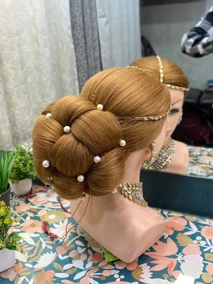 Another angle of the woven bun, showing how it is constructed. This demonstrates the technical skill required to create such a large and perfectly structured bridal hairstyle.