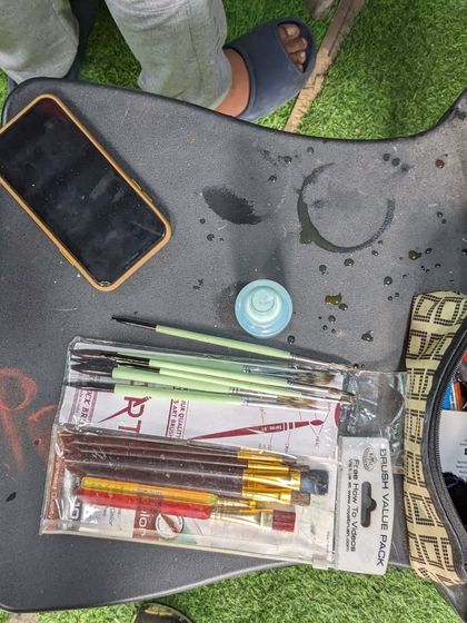 The artist's workspace. A simple setup with brushes, paints, and a phone for reference is all you need to start creating.