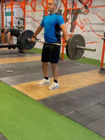 This client is in the hang position, ready to execute a snatch. Notice the focus on maintaining a flat back and engaged lats.