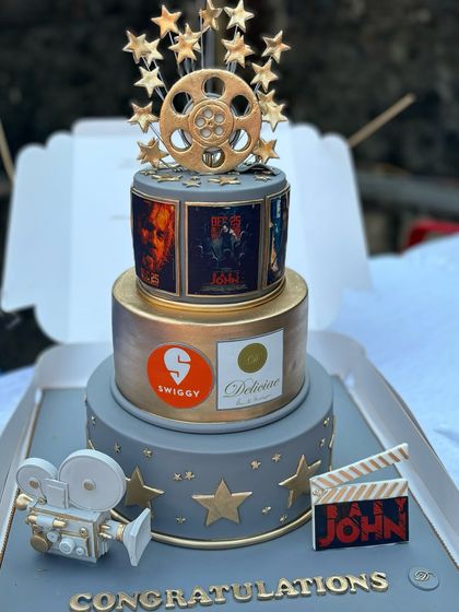This movie themed cake was a special collaboration with Swiggy to celebrate Varun Dhawan's film, 'Baby John'. The design incorporates film reels, a movie camera, and posters from the movie.