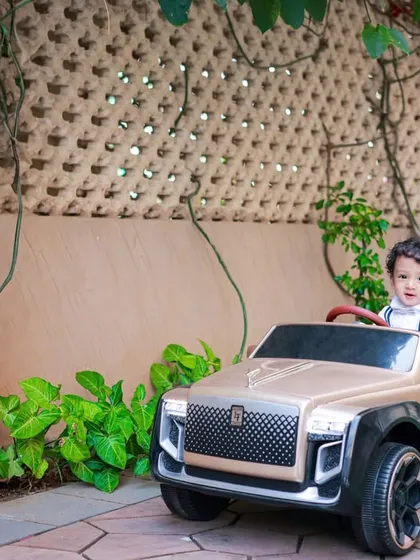 Driving through a leafy pathway, this little one is on an adventure. Outdoor settings provide endless opportunities for dynamic and candid action shots.