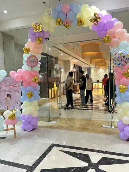 A grand entrance arch for a unicorn-themed party, made with pastel balloons and gold butterfly accents, welcoming guests to the celebration.