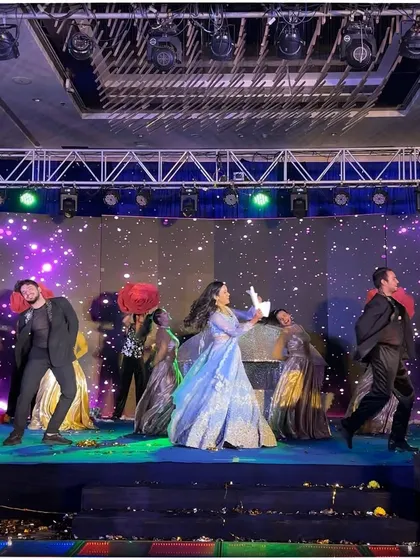 A joyful moment from the bride's performance, dancing with her troupe amidst a shower of petals.