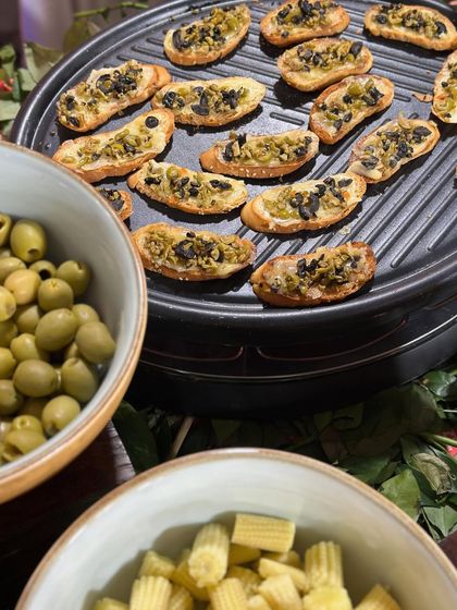A platter of olive tapenade crostini. This simple yet elegant finger food is a staple of our Mediterranean and European menus, perfect for pass-around service.