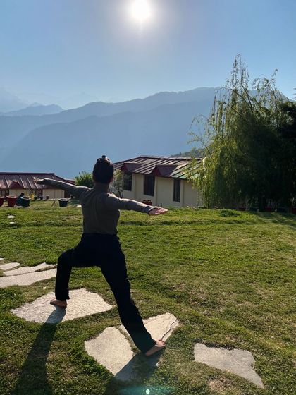 Holding Virabhadrasana II, Warrior II, during a morning yoga session in the Himalayas. The pose feels incredibly powerful when you are facing the vastness of the mountains, grounding you in the present moment.