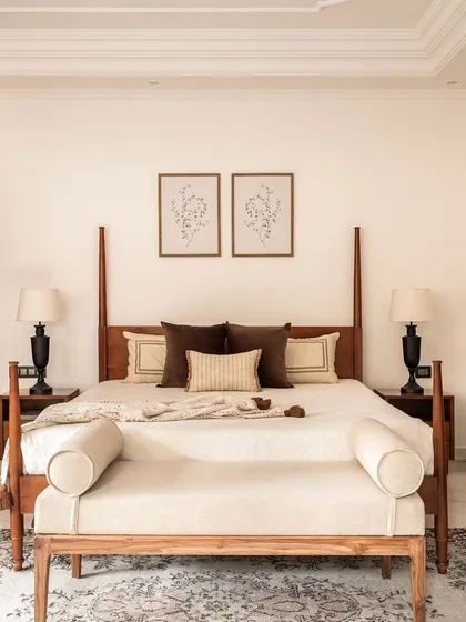 A direct view of the four-poster bed, showcasing its clean lines and the simple, elegant styling. The matching bedside tables and lamps create a sense of symmetry and order, contributing to the room's tranquil mood.