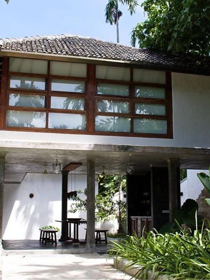 The main villa's entrance foyer during the day, showing the open, pavilion-like structure that invites the landscape in.