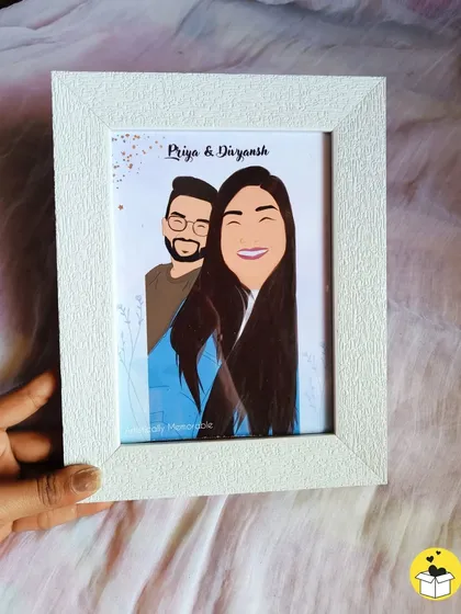 A close-up of a custom couple's portrait in a textured white frame, perfect for an engagement gift. The names "Priya & Divyansh" are elegantly written above the illustration.