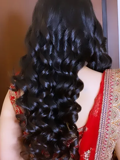 A close-up of beautiful, glossy curls for a reception. This simple yet glamorous hairstyle is perfect for a modern bride who wants her hair to shine.