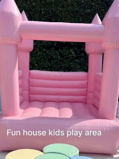 A close-up of our vibrant pink bounce castle, showcasing its classic castle design with four turrets.