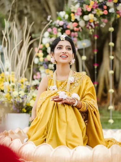 A radiant bride at her Haldi ceremony. I designed this custom lotus-shaped seating surrounded by soft, pastel flowers to make her feel like she was floating in a garden.