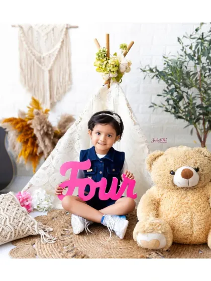 This cool kid is ready to rock her fourth birthday shoot. The guitar and teddy bear props add a fun, playful vibe to the session.
