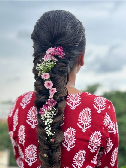 A detailed close up of the fishtail braid, highlighting the texture and the delicate flowers woven into it.
