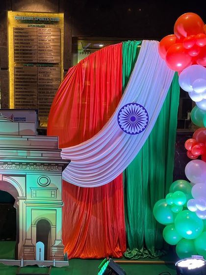A Republic Day photo booth featuring a replica of the India Gate, a tri-color balloon arch, and a backdrop of saffron, white, and green drapes. It's a perfect spot for capturing patriotic memories.