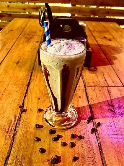 A tall glass of our refreshing cold coffee, drizzled with chocolate sauce.