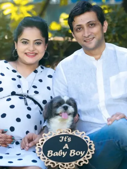 Your fur baby is family too. This happy couple included their adorable dog in their announcement photo, making their family portrait complete and adding a touch of playful joy to their maternity session.