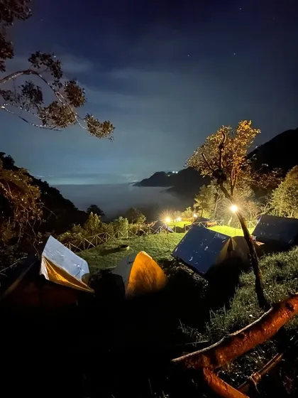 Our campsite at night, lit up under a starry sky with a river of clouds settled in the valley below. It's a surreal experience.