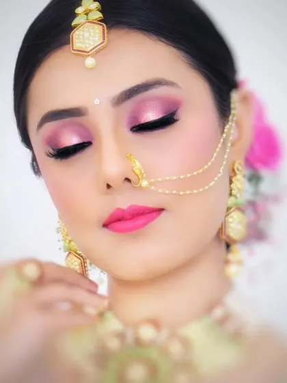 A close-up of the client's dramatic pink eye makeup. The hair is pulled back into a sleek bun, ensuring the makeup is the star of the show.