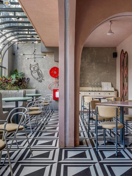 The semi-outdoor area at Hangover, with its striking black-and-white geometric floor tiles and barrel-vaulted glass roof. This space offers an al-fresco feel while being protected from the elements.