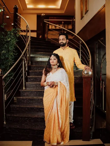 A royal portrait of the couple during their Haldi ceremony. The bride's makeup is elegant and understated, a perfect match for her sophisticated saree.