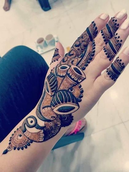 A unique and modern design featuring musical drums (tabla) as part of a flowing Arabic-style pattern.