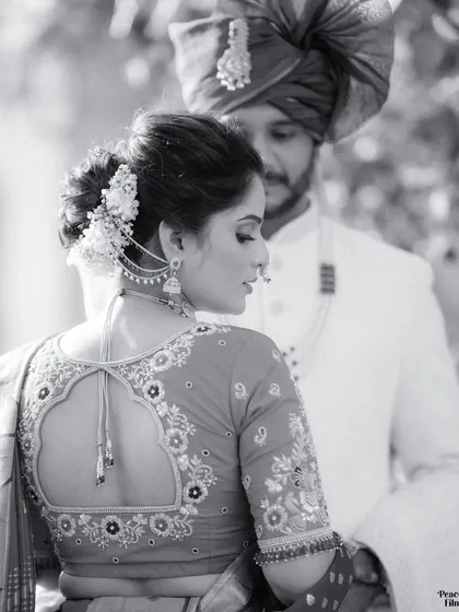 An artistic portrait focusing on the bride's traditional attire. The black and white format emphasizes the beautiful details of her blouse and hairstyle.