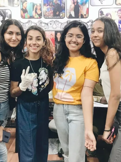 A group of friends posing together after a successful tattoo session at the studio.
