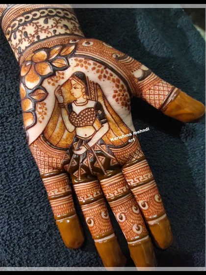 A close-up of a single hand showcasing a beautifully detailed portrait of a bride. This highlights the fine line work and shading I use to create realistic and expressive figures in my mehendi art.